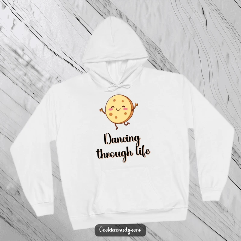 Funny, smiling round cookie character with short legs doing a joyful dance, featured on a warm hoodie.